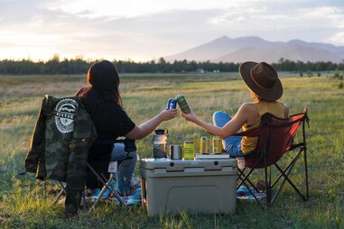 2 friends drinking beer while looking into the distance