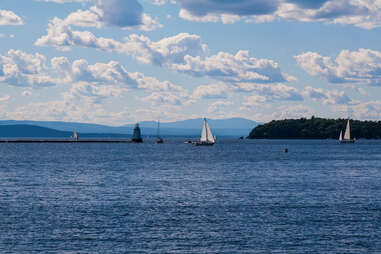 sailboats on a lake with mountains surrounding