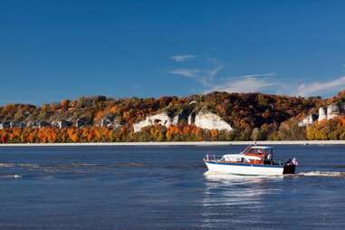 a boat sailing past beautiful bluff cliffs