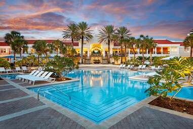 Large hotel pool beneath palm trees