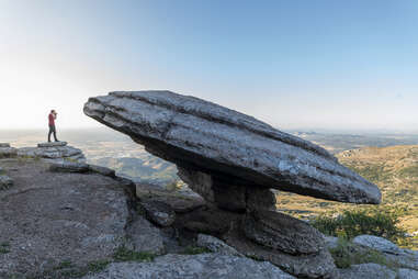 Landscape with a man taking pictures of a large circular rock in El Torcal de Antequera Natural Park