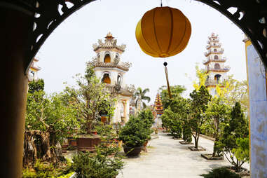 Lantern hanging in archway over Hanoi garden