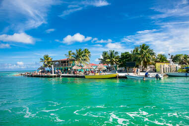 colorful boats surrounding a small palm tree-lined island in the caribbean sea