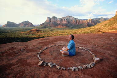 a man meditating in a circle of rocks