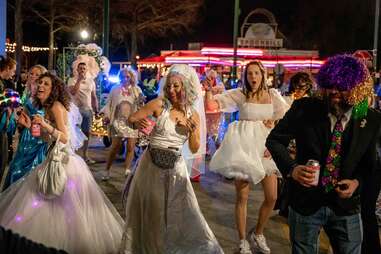 people dance in wedding dresses in the street
