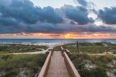 a beach boardwalk at sunset