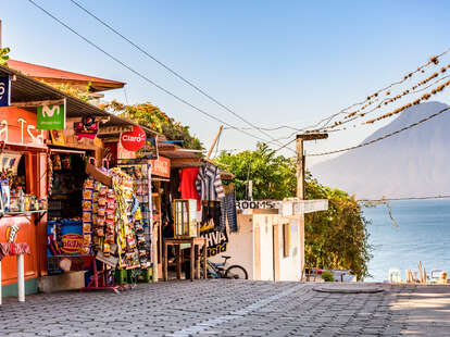 a shop on a hill leading to a lake and volcano