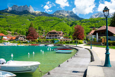 boats and a boardwalk near a small mountain-lake town