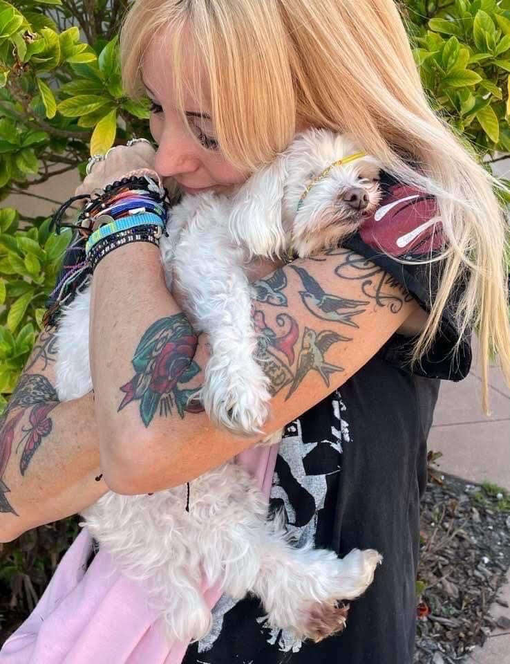 Woman hugs senior dog.