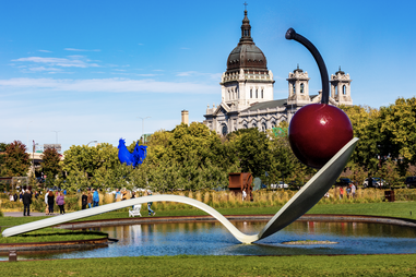 a large park sculpture of a cherry on a spoon