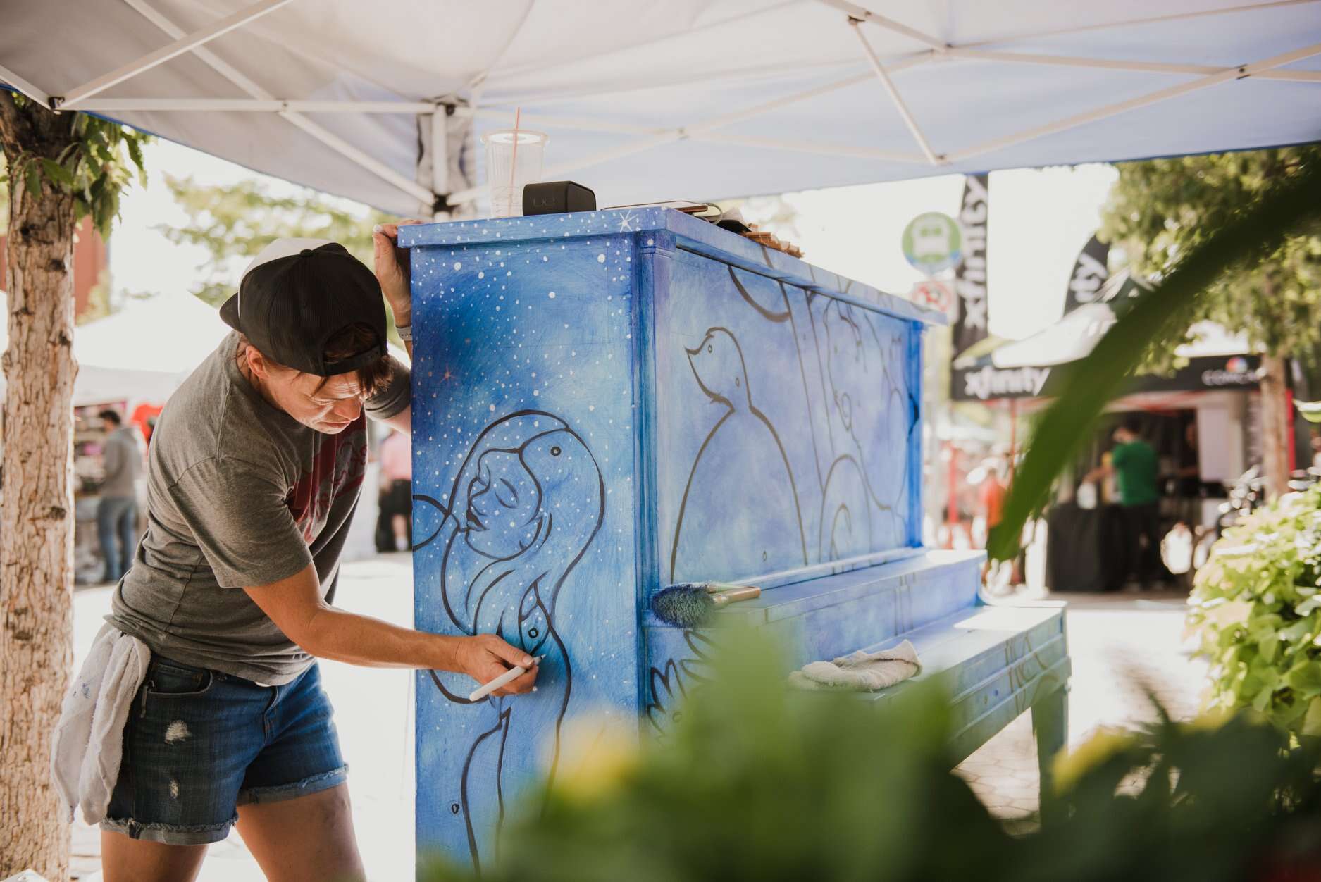 a person painting the side of a piano