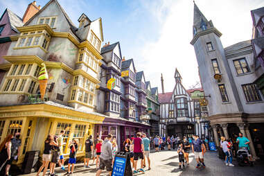 people walking through a medieval, magical town square