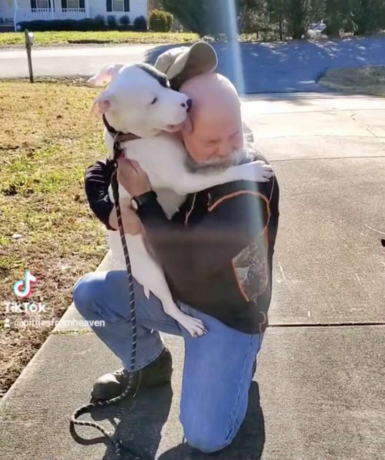 A happy dog hugs her new dad.