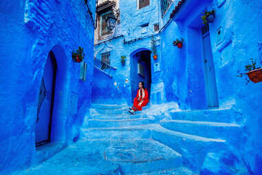 woman sitting on steps of the blue city, morocco