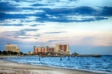 Casinos and buildings along Gulf Coast shore at sunset