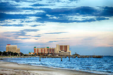 Casinos and buildings along Gulf Coast shore at sunset