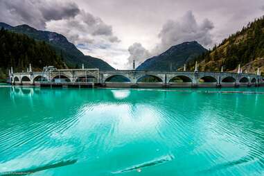 diablo dam surrounded by a mountains of pine trees