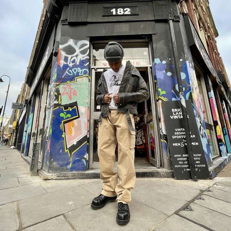 young man standing outside vintage store