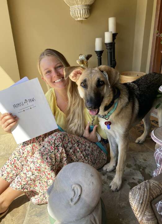 dog stands next to owner