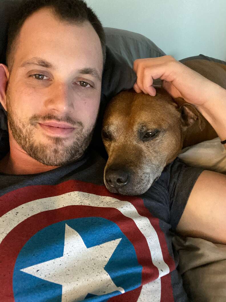 man and dog cuddle 