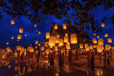 Monks releasing lights in floating balloons made of paper 