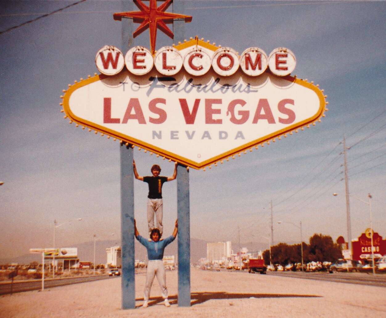 men standing back Welcome to Las Vegas sign