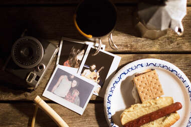 smores, hot dog, and polaroids on a wooden table