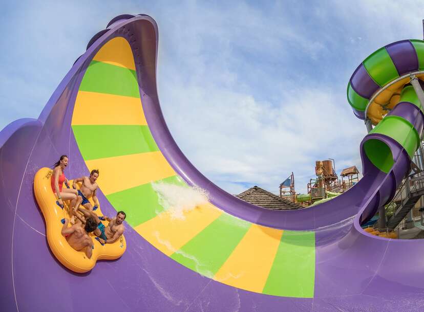 People riding the half pipe waterslide