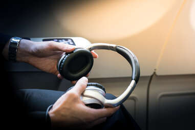 A passenger holding headphones