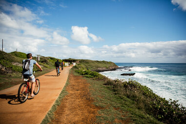 people biking alongside ocean