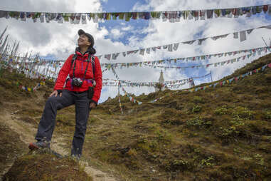 woman standing in front of prayer flags