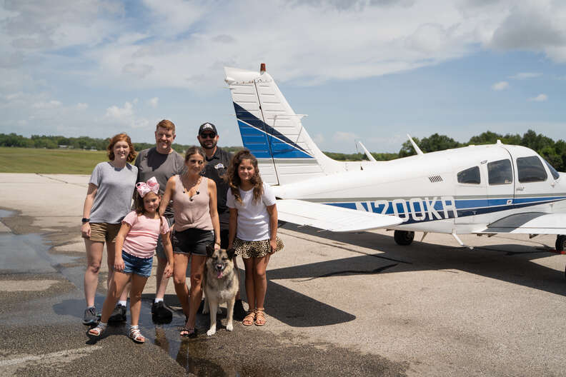 family standing in front of plane 