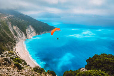 Aerial view of paraglider flying over Myrtos beach