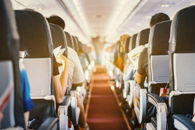 Interior of airplane with passengers sitting on seats