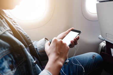 man sits in airplane cell phone