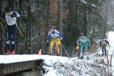 a group of people skiing near a small lodge