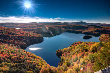 a small roadside cabin near a lake and enormous mountain in fall