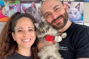 man and woman posing with a cat