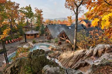 overhead view of thermal pool surrounded by cabins and fall foliage