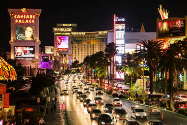 traffic on a crowded street in a glitzy, palm-lined city