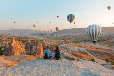 Hot air balloon flying over rock landscape