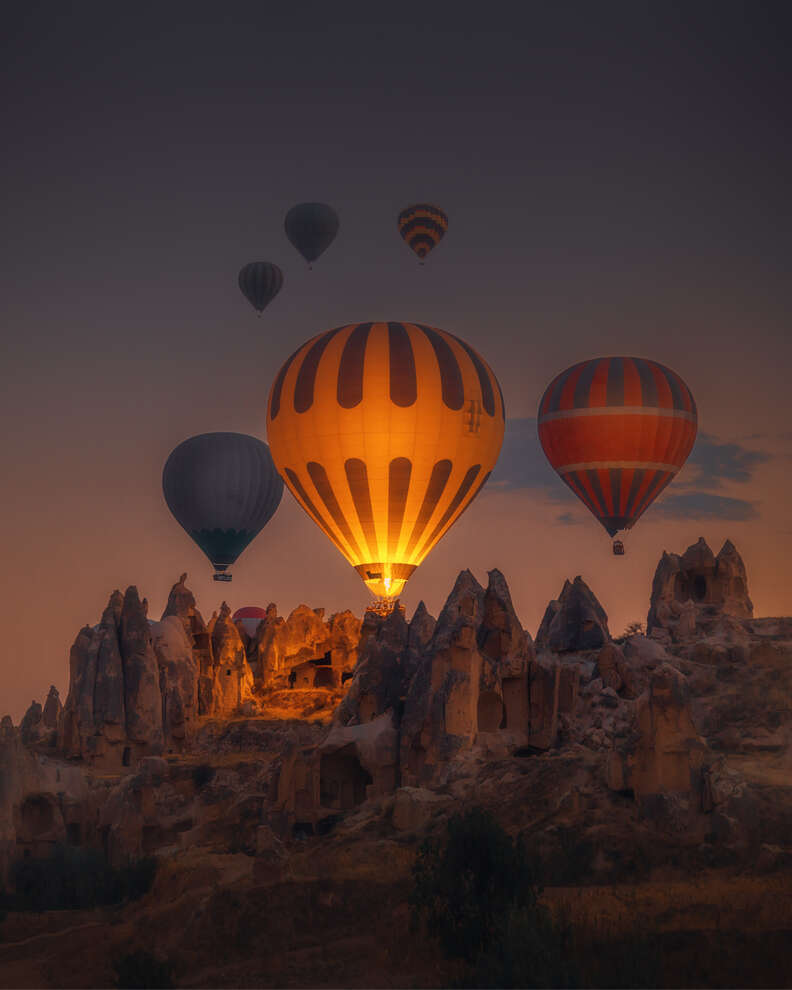 Hot Air balloons flying over rock formations at sunrise