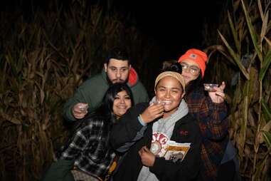 group of friends drinking in maze at night