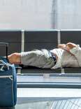 man laying on airport seats