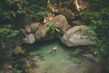 man floating in natural pool, mossman gorge
