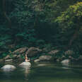 woman sitting on a rock at mossman gorge