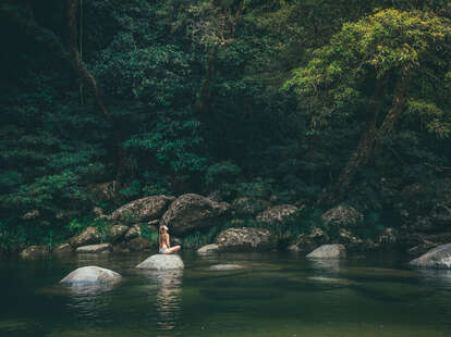 woman sitting on a rock at mossman gorge