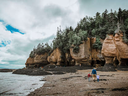 Father and children walking by the river on a cloudy day