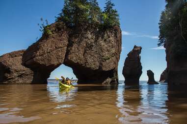 kayak under rock arch