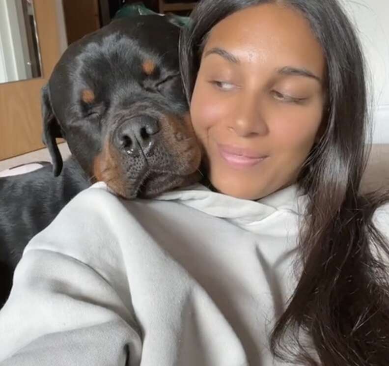 A dog leans over his mom's shoulder.